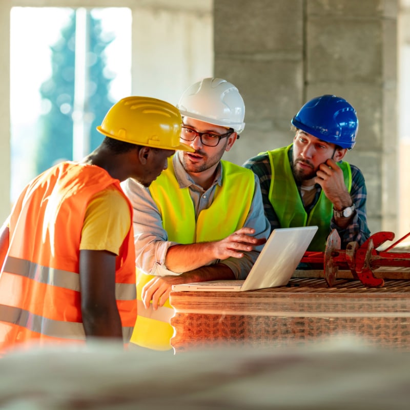Construction workers collaborating on project documents.