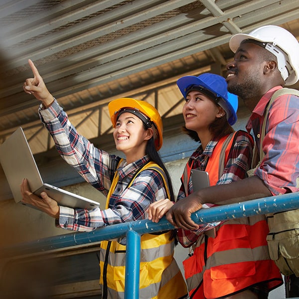 Workers in manufacturing plant collaborating on documents.